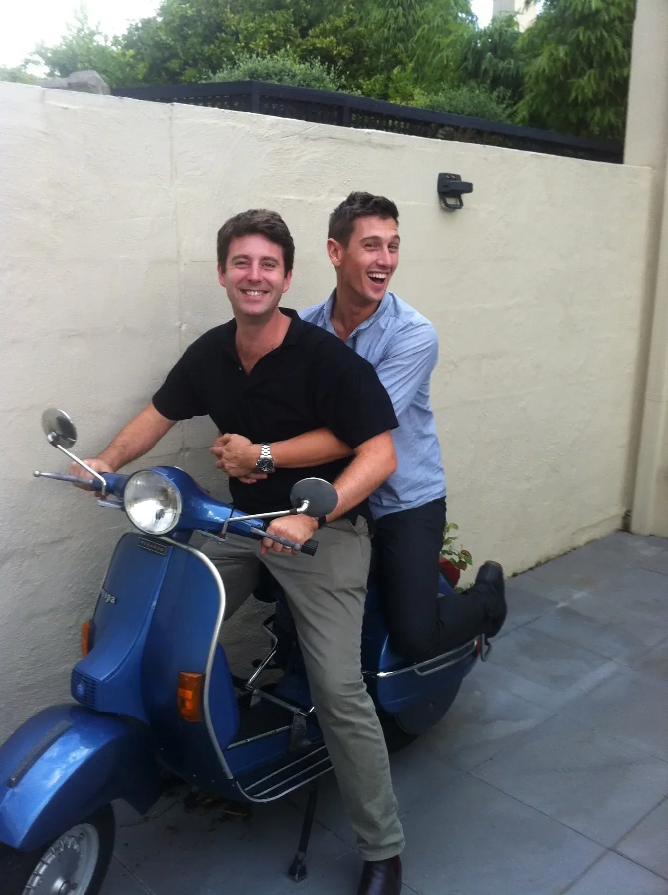Andy and Matt laughing on Matt's blue Vespa, years before Mangia Disco